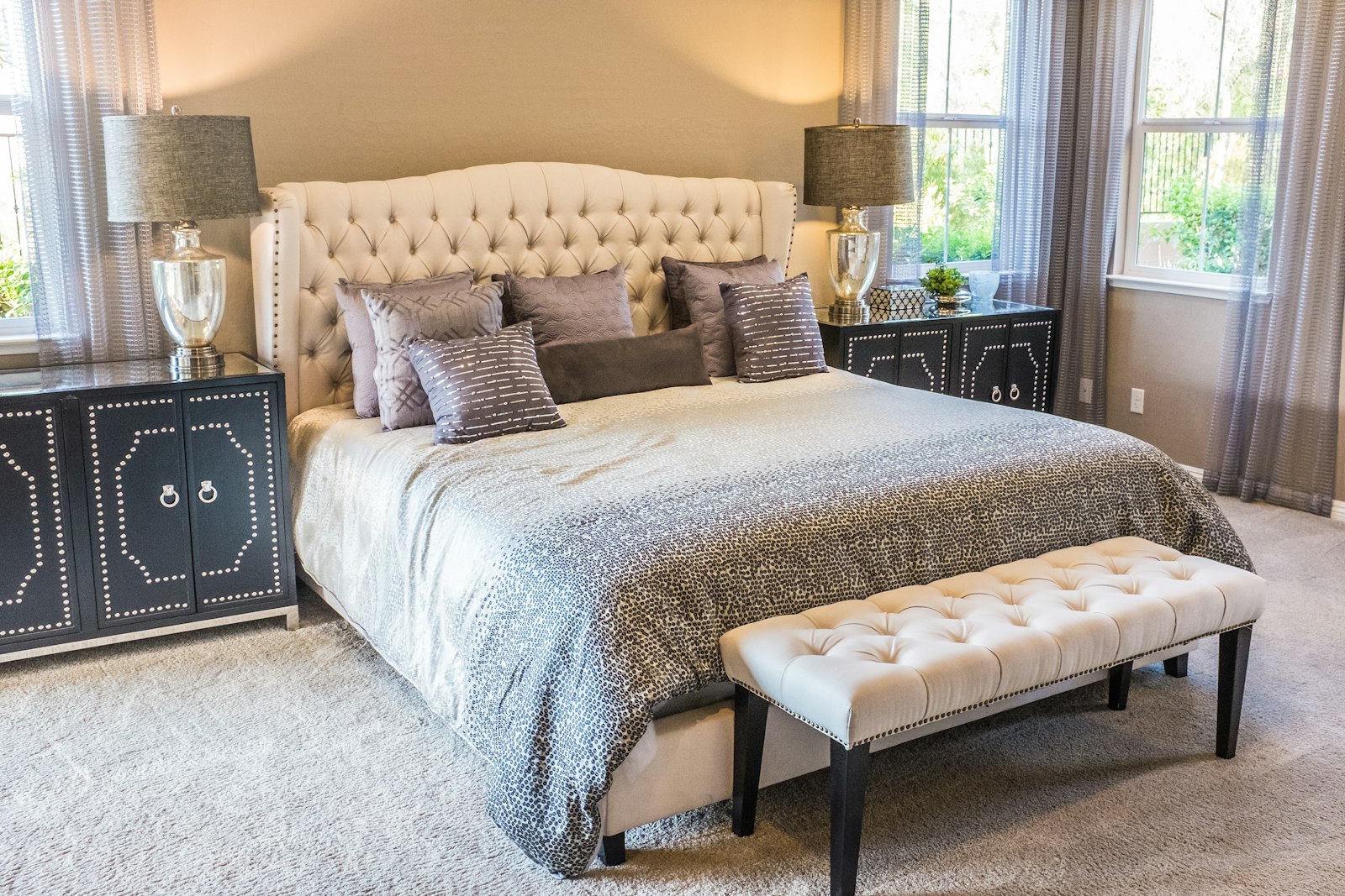 Bedroom with a padded headboard and two windows